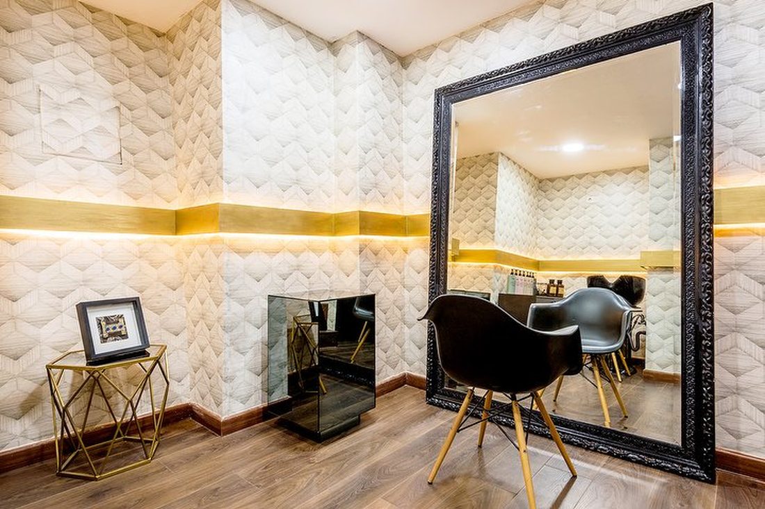 Sala con pared de relieve geométrico y banda de latón iluminada